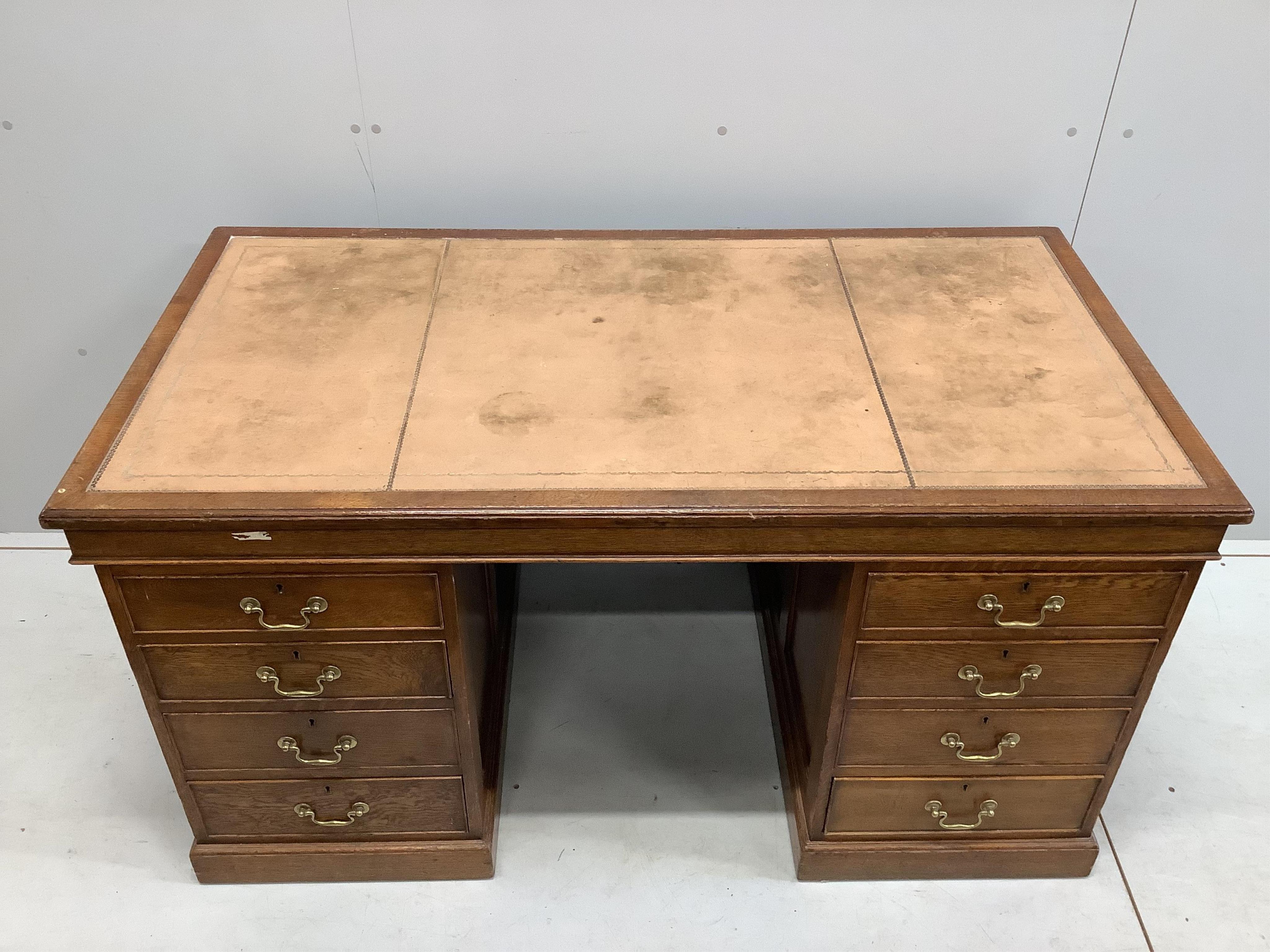 An early 20th century oak pedestal desk, bears George V cypher and stamped John Walsh Ltd Sheffield, width 142cm, depth 75cm, height 75cm. Condition - fair